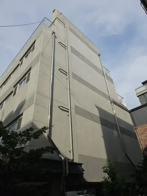 회색 외벽 5층 건물 우수관교체 후 측면 배관